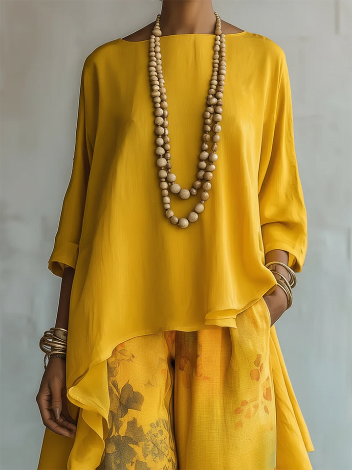 Completo estivo donna con blusa asimmetrica e vivaci pantaloni floreali. Ideale per un look chic.