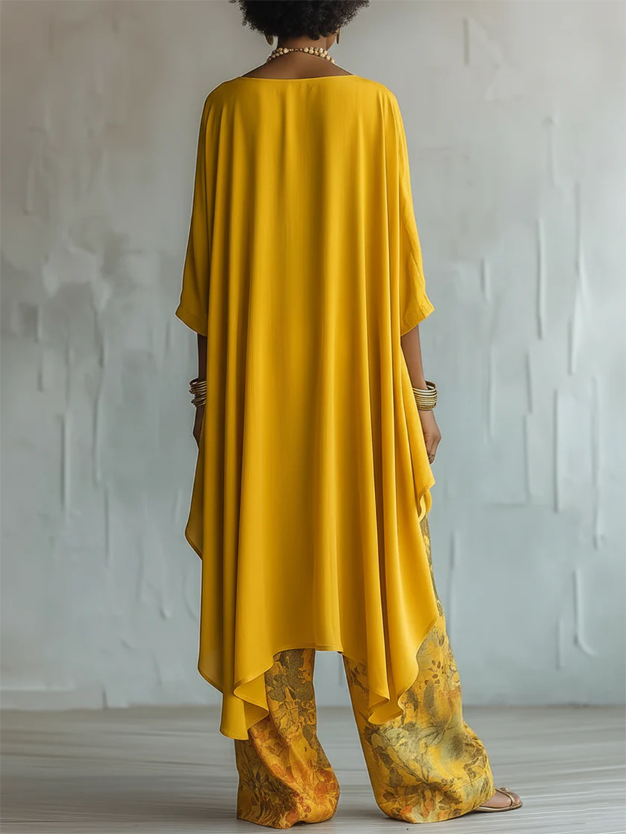 Modella indossa completo donna boho: blusa asimmetrica e pantaloni ampi a fantasia floreale. Stile casual.