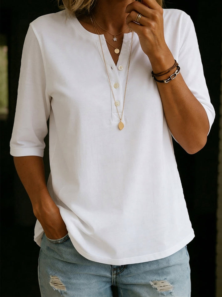 Uomo sorridente indossa T-shirt Henley casual grigia. Stile rilassato, ideale per tempo libero in primavera/estate, comfort garantito.