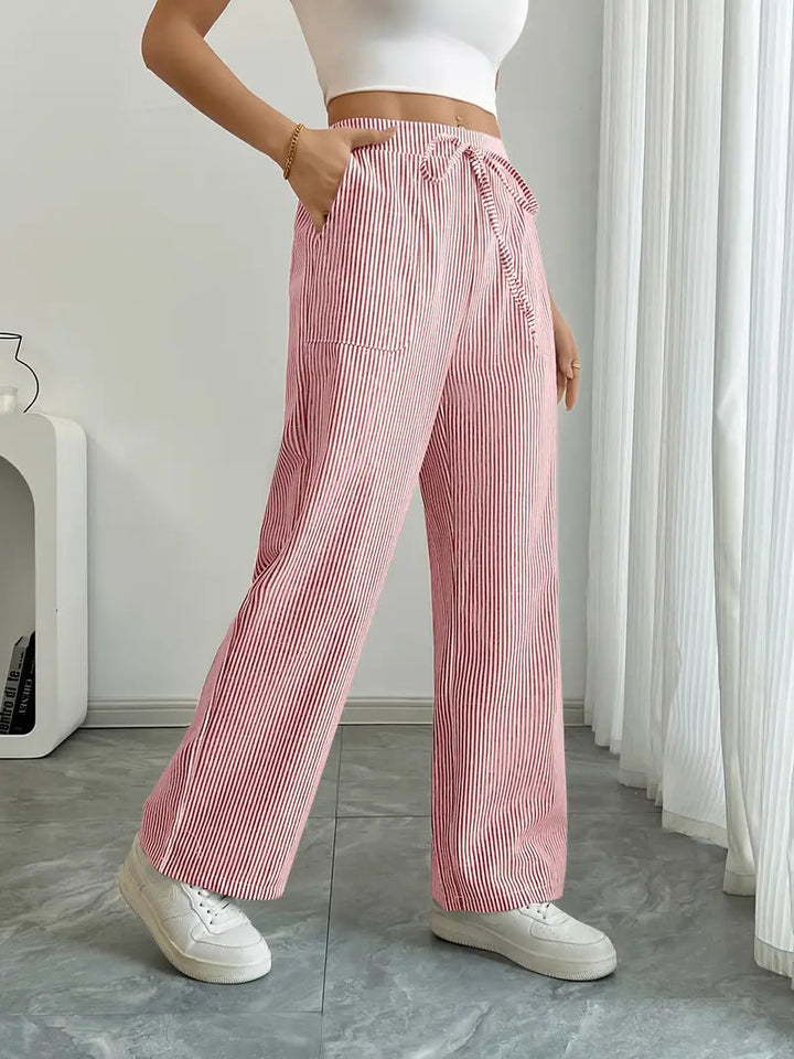 Dettaglio della vita alta dei pantaloni donna a righe e gamba larga. Enfatizza comfort, vestibilità e stile estivo.