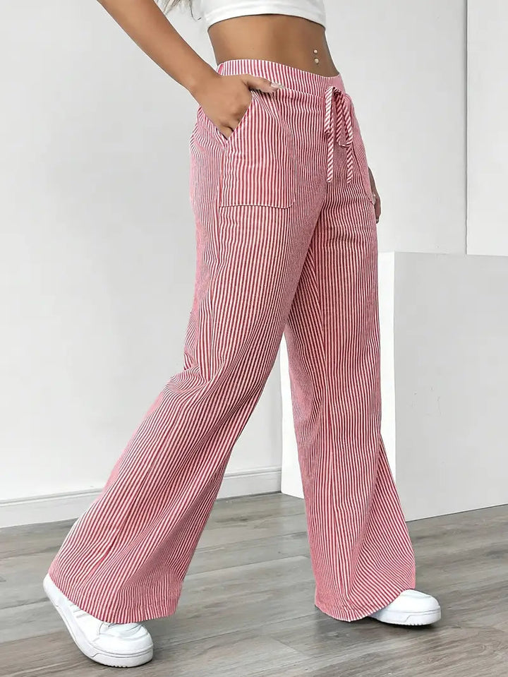 Pantaloni donna eleganti a righe, vita alta, gamba larga. Look serale sofisticato, comodo e di tendenza. Moda donna.