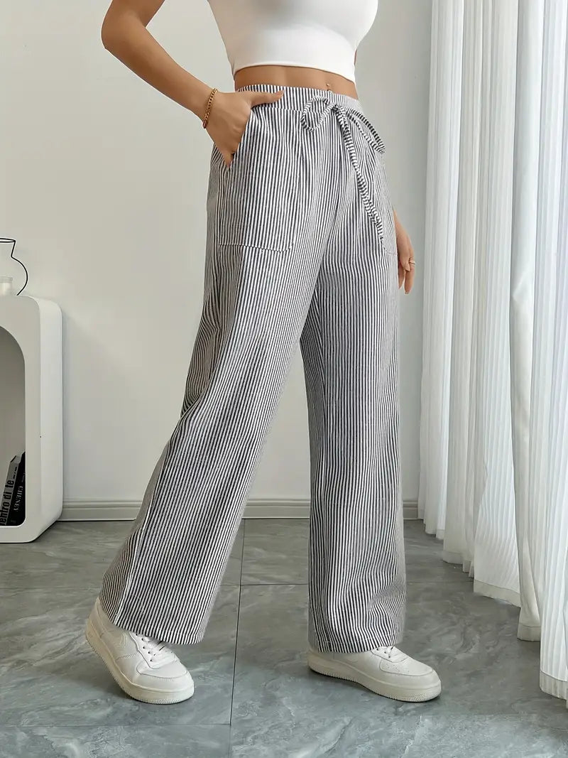 Modella rilassata in pantaloni donna a righe vita alta, gamba larga. Comfort e stile estivo, perfetti per il tempo libero.