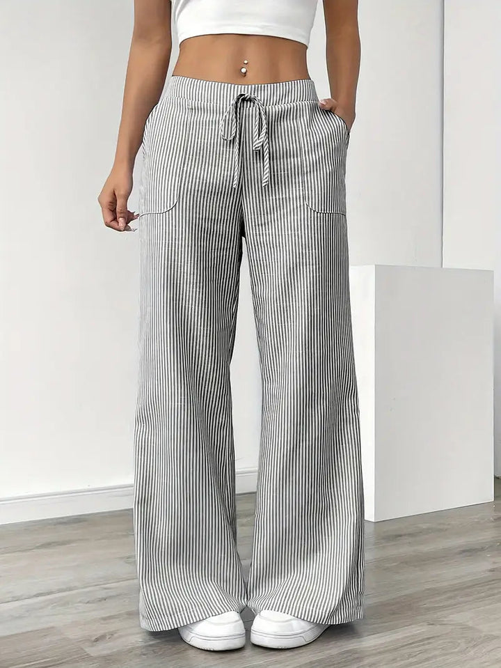 Pantaloni donna a gamba larga a righe, vista posteriore. Vita alta che valorizza la figura. Moda casual chic e comoda.