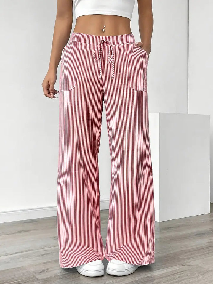 Modella con pantaloni donna a righe, vita alta, gamba larga. Stile elegante e comodo per outfit estivi. Moda versatile.