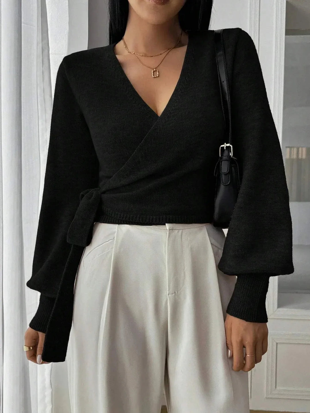 Maglione donna con design avvolgente moderno e maniche a sbuffo. Un capo versatile per un look chic e femminile.