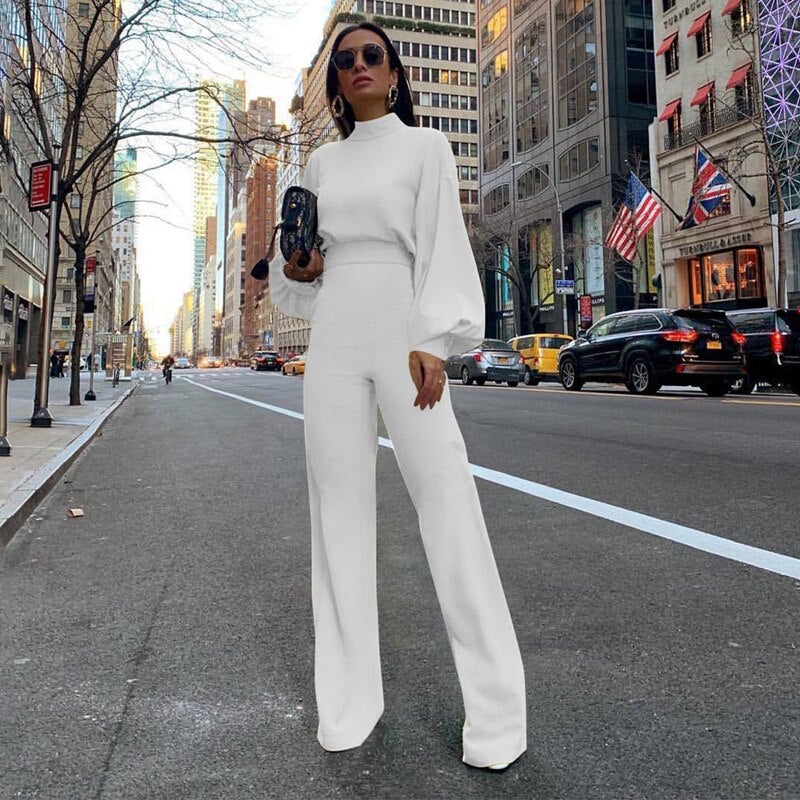 Tuta elegante da donna bianca, completa di colletto in piedi. Un abbigliamento formale sofisticato.