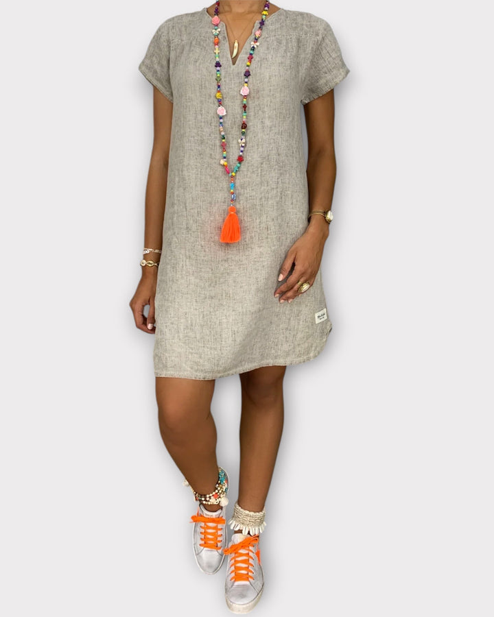 Elegante vestito tunica estivo da donna con ricami etnici e profondo scollo a V, perfetto per la spiaggia.