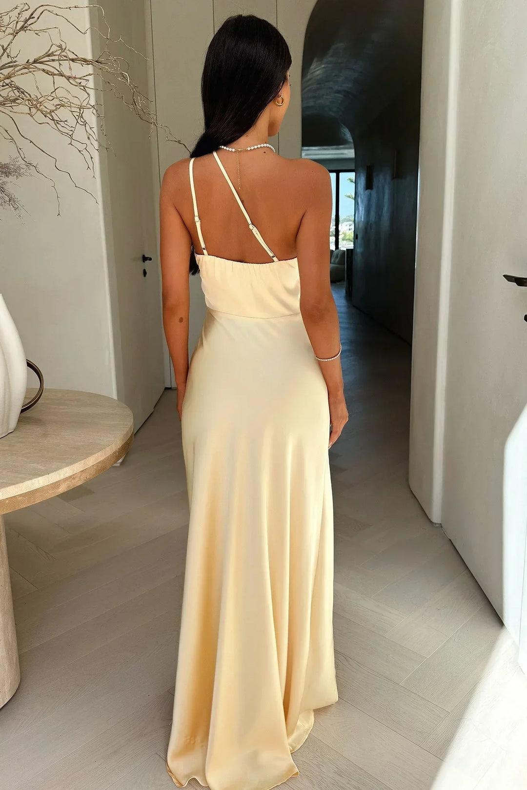 Abito lungo beige femminile con taglio asimmetrico e spacco, vestito chic per la moda donna elegante e raffinata.