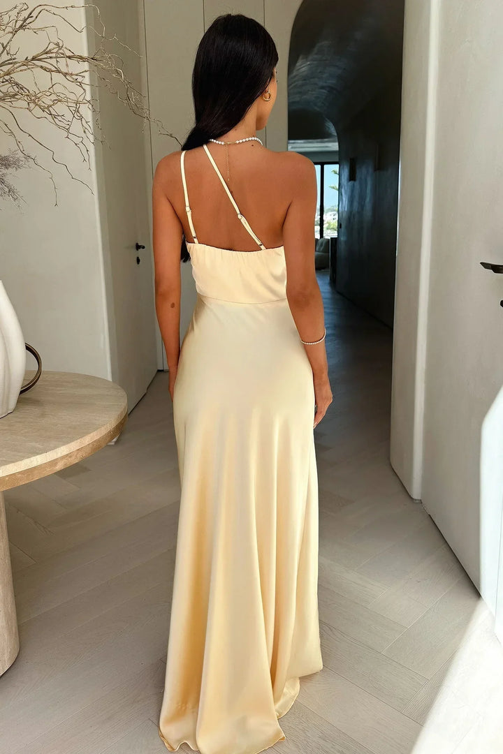 Abito lungo beige femminile con taglio asimmetrico e spacco, vestito chic per la moda donna elegante e raffinata.