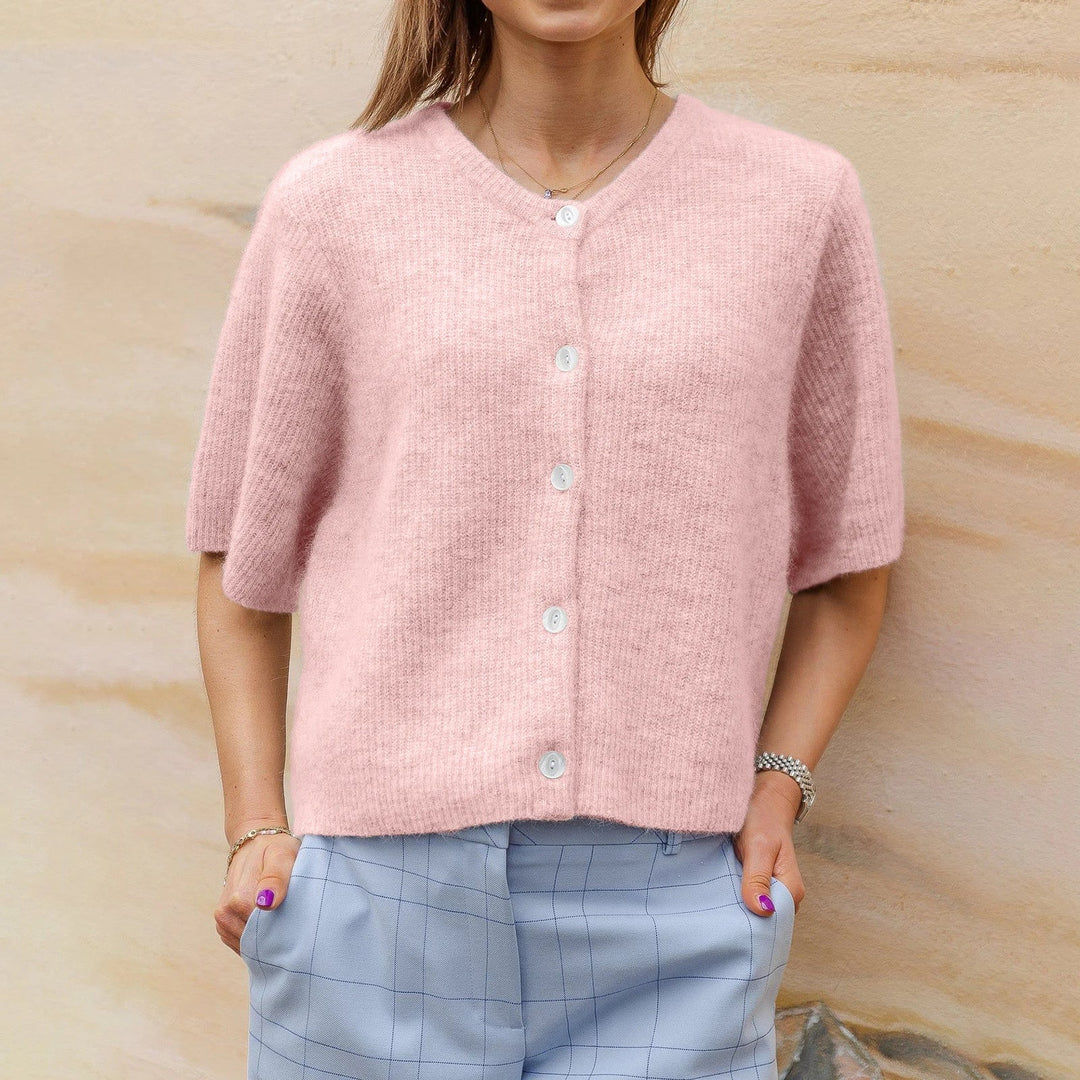 Cardigan donna rosa a maniche corte, stile moderno e comfort. Perfetto per look estivi casual ed eleganti.