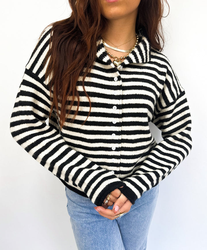 Cardigan donna elegante bianco a righe nere e bottoni. Perfetto per outfit casual o primaverili.