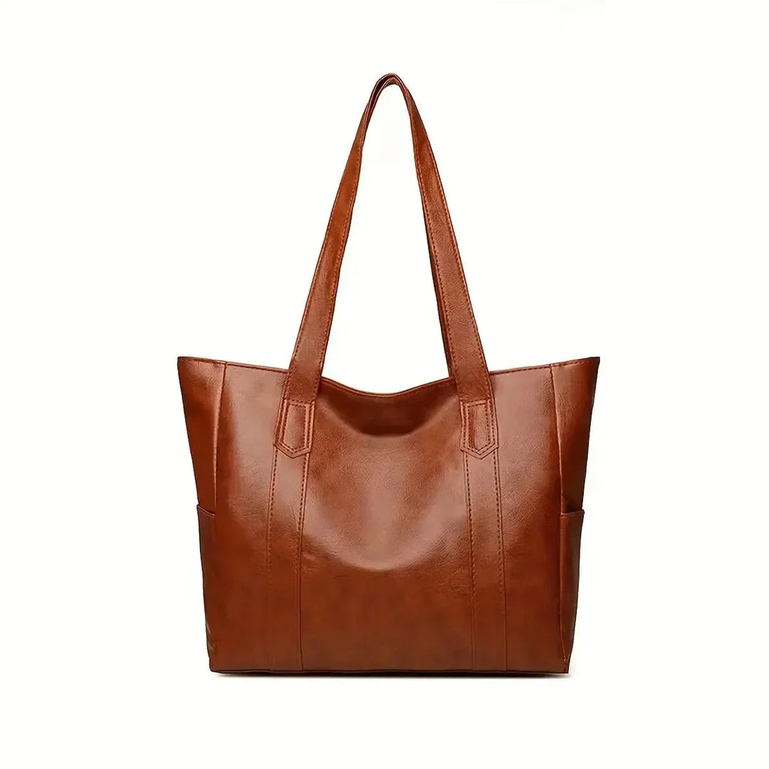 Dettaglio texture vera pelle borsa a spalla donna. Qualità artigianale per un accessorio classico.