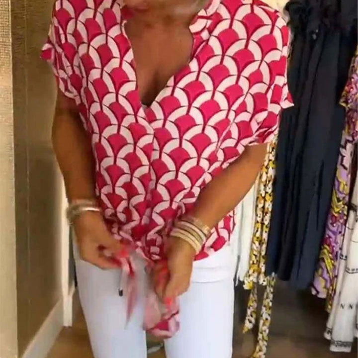 Top donna con stampa vivace e colorata, scollo a V e maniche corte. Ideale per un look estivo casual e trendy.