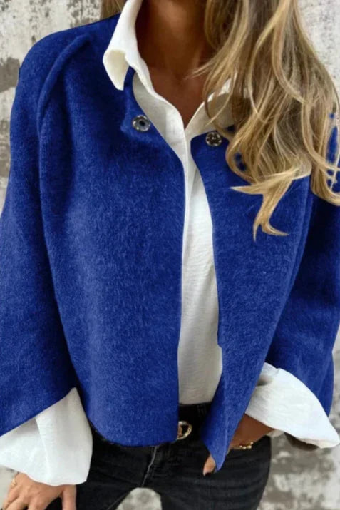 Giacca corta blu da donna, maniche svasate, capo primaverile elegante per un outfit versatile.