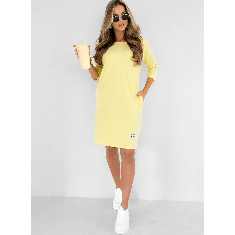 Mini abito giallo donna con maniche 3/4, scollo rotondo confortevole e pratiche tasche laterali estive.