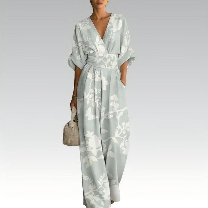 Tuta elegante donna intera con stampa floreale vivace, scollo a V e pantaloni a gamba ampia. Abbigliamento estivo.