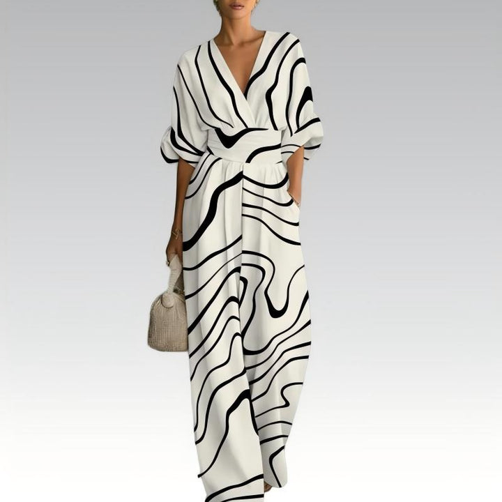 Donna di spalle in tuta floreale con scollo a V, evidenziando il taglio elegante e la gamba ampia per comfort.