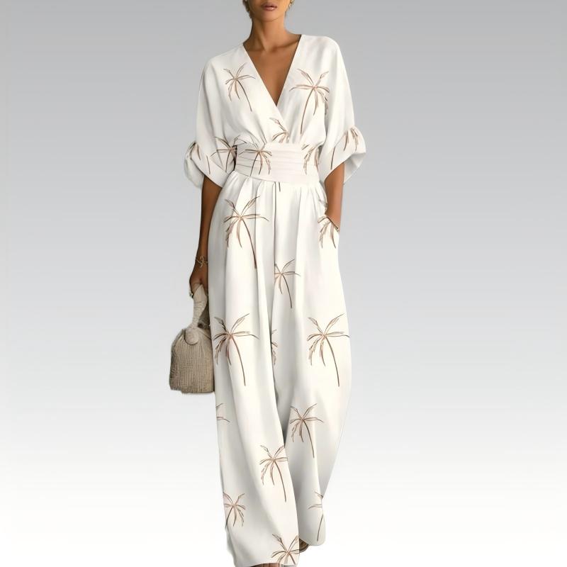 Tuta donna estiva floreale, scollo a V e gamba ampia, indossata per un look vacanza casual chic e confortevole.
