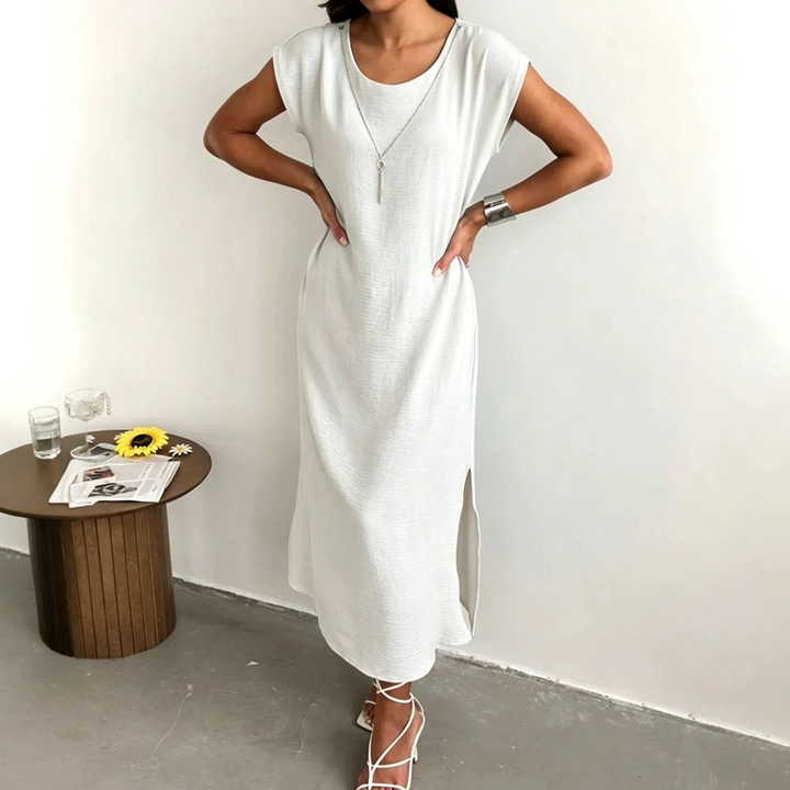 Splendido abito midi donna in micro-crepe testurizzato, con spacco laterale, ideale per un'eleganza estiva raffinata.