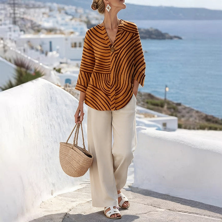 Completo due pezzi donna a righe per outfit vacanza. Pantaloni larghi e top coordinato, look elegante e confortevole.