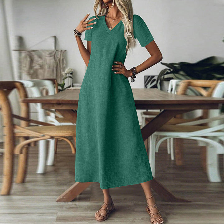 Donna in abito maxi estivo, scollo a V, tasche. Eleganza e comfort in un vestito lungo perfetto per l'estate.