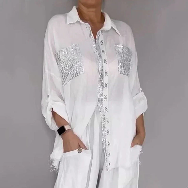Look serale: completo elegante donna con top paillettes scintillanti e pantaloni morbidi neri. Glamour assicurato.