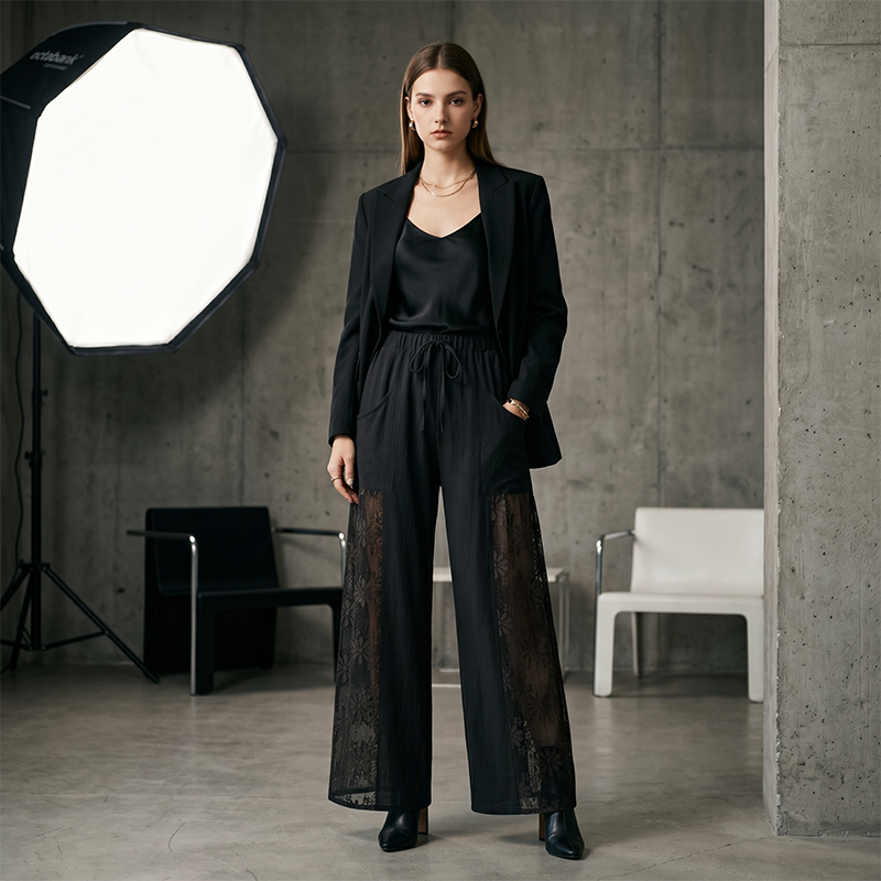 Dettaglio del pizzo elegante sui pantaloni donna fluidi, con cordoncino in vita per una vestibilità perfetta.