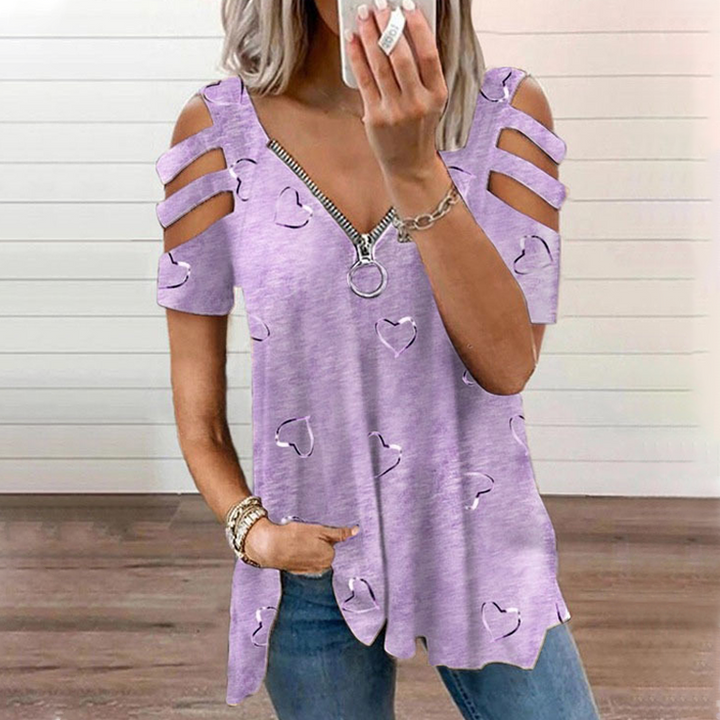 Top donna a maniche corte con spalle scoperte. Dettagli: zip decorativa e romantici cuori stampati. Vestibilità ampia.