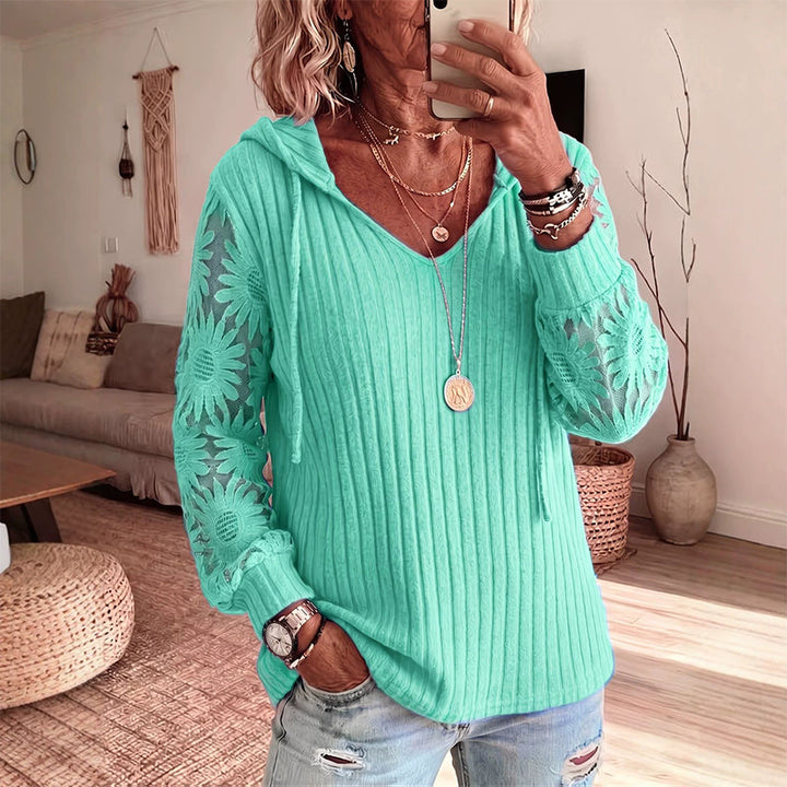 Top donna casual con comodo cappuccio e dettagli raffinati in pizzo floreale sulle maniche lunghe.