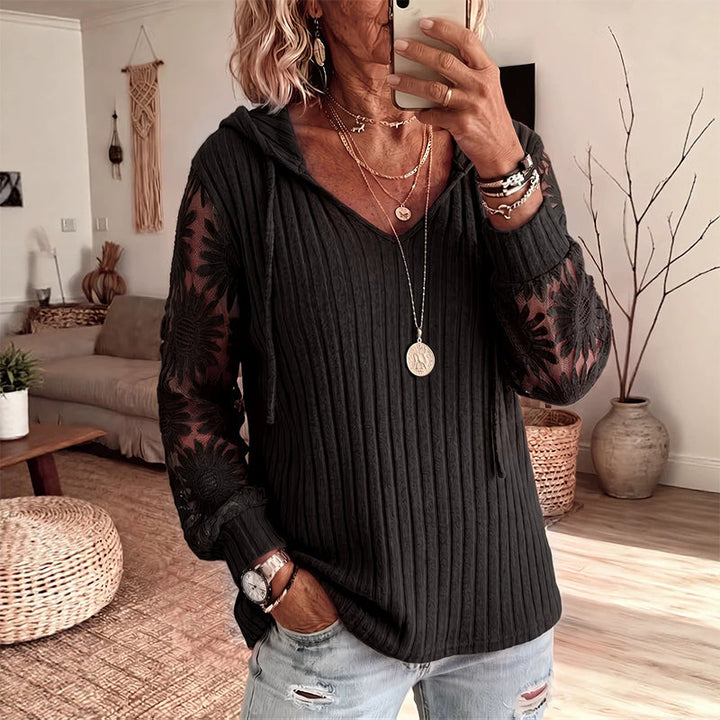 Moda femminile: top con cappuccio e maniche in delicato pizzo floreale, un capo versatile e alla moda.