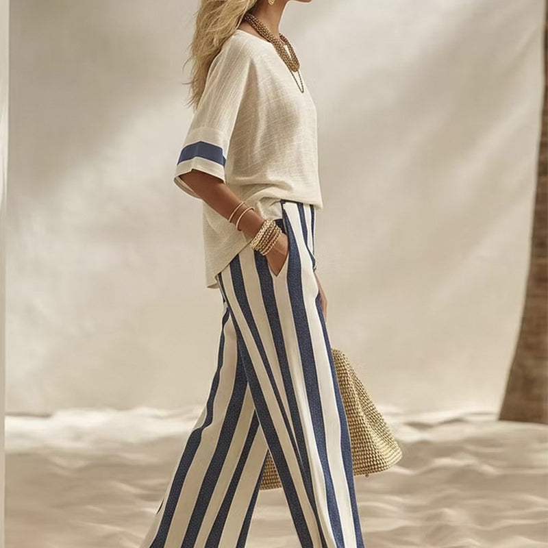 Completo due pezzi donna con pantaloni palazzo a righe verticali e blusa leggera.