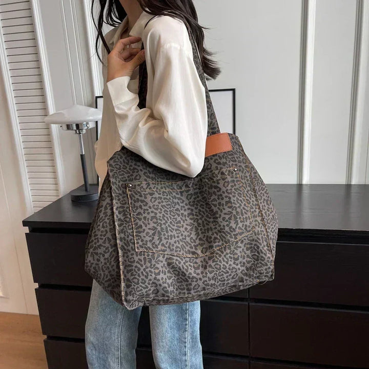 Dettaglio ravvicinato della stampa leopardata marrone, beige e radice di rosa su borsa tote donna, alta qualità.