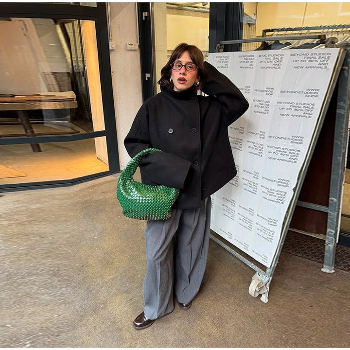 Dettaglio: collo alto e bottoni di un elegante cappotto invernale donna. Moda e calore per l'inverno.
