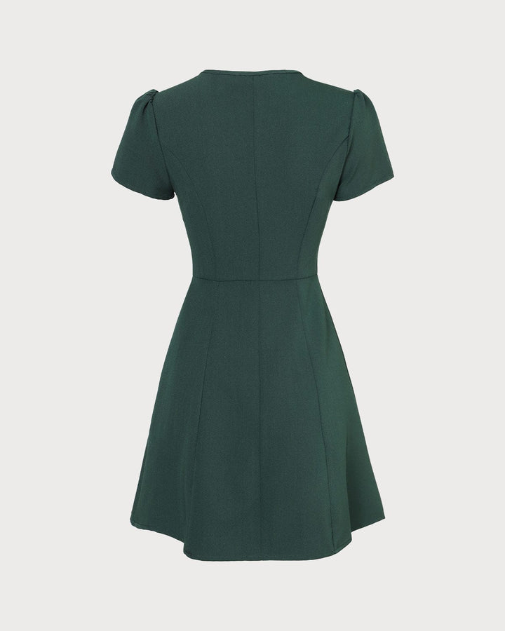 Moda donna: abito mini verde scuro, scollo a V, manica corta, linea ad A. Un vestito versatile per ogni guardaroba.