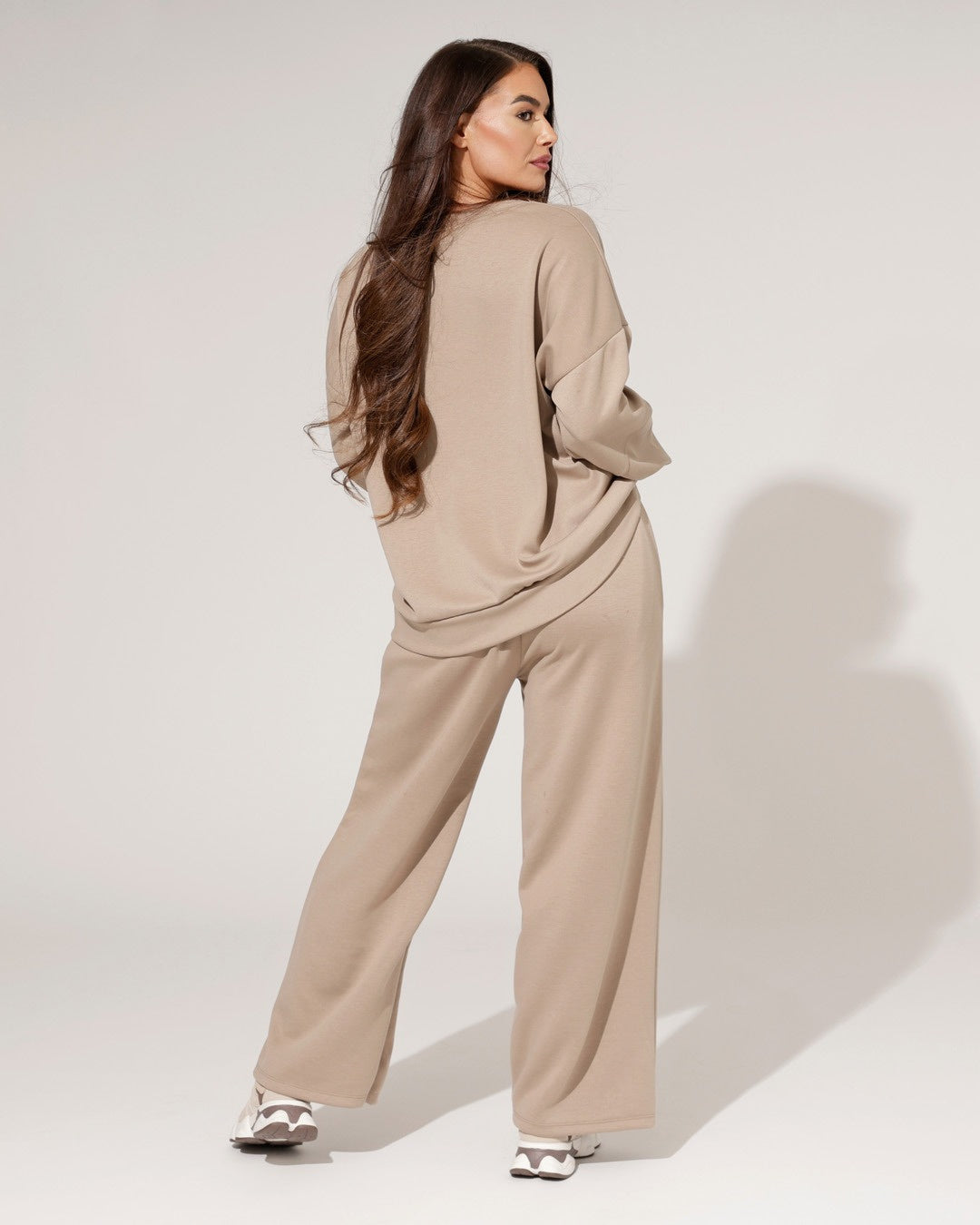 Modello completo loungewear donna con maglione ampio e pantaloni a gamba larga, ideale per stile comodo e casa.