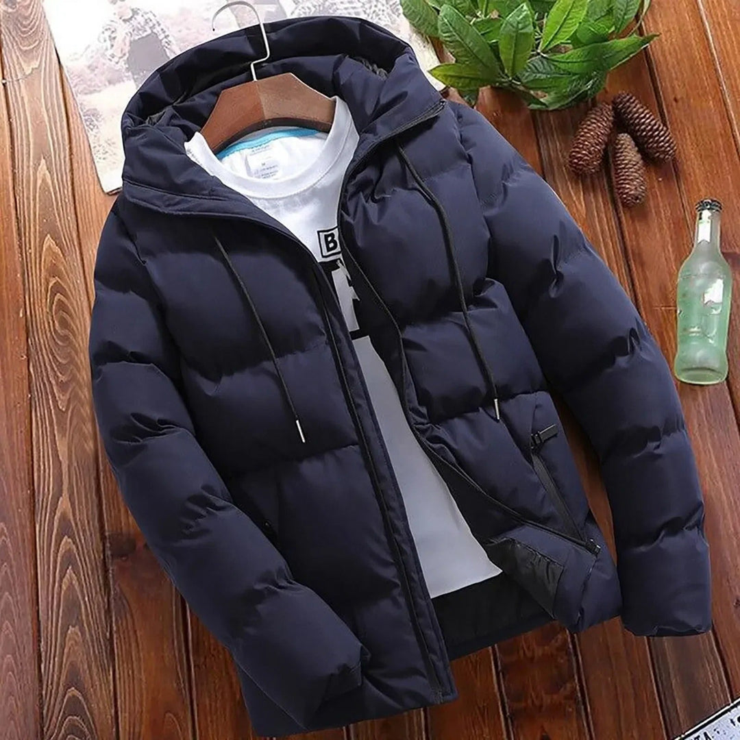 Giacca invernale da uomo con cappuccio e design trapuntato. Piumino caldo e antivento per un look casual.