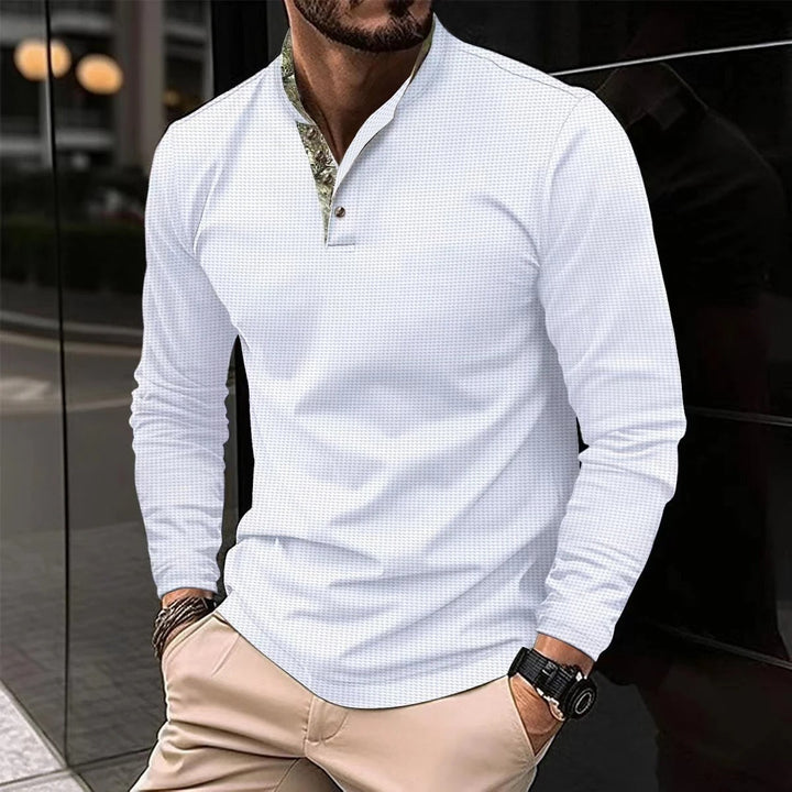 Uomo indossa polo a maniche lunghe, look versatile e moderno. Ideale per un abbigliamento maschile di tendenza.
