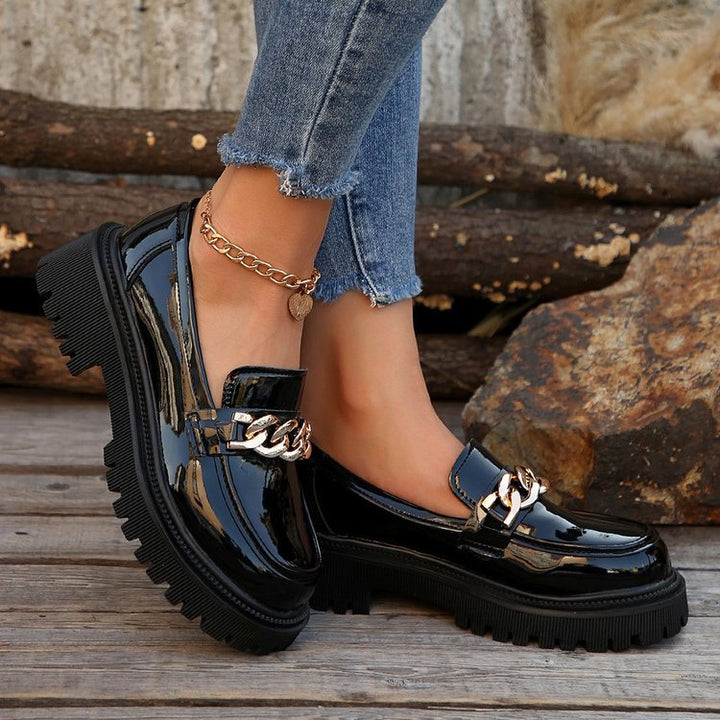 Mocassini donna neri platform con catena oro, stile urbano e perfetti per la moda autunnale.
