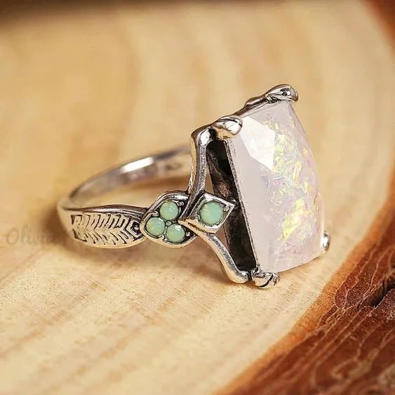 Anello vintage da donna in argento con opale bianco sfaccettato e raffinata incisione a piuma, elegante gioiello.