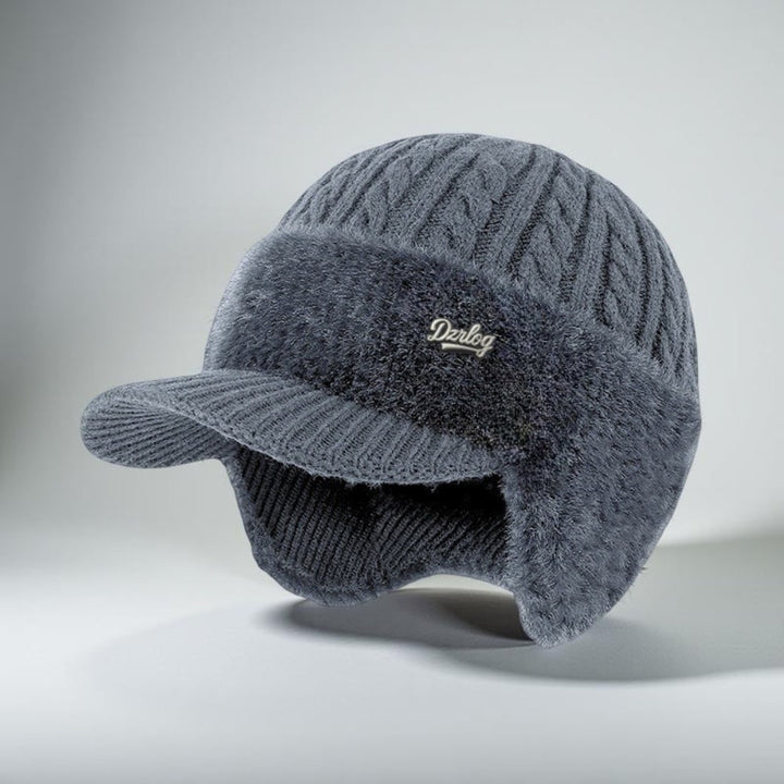 Morbido cappello in maglia lavorato a trecce, unisex, con visiera protettiva e paraorecchie.