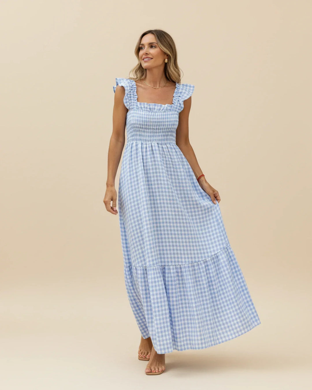 Abito maxi a quadretti con balze, collo quadrato, senza maniche, ideale per serate estive eleganti.