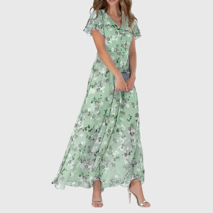 Vestito lungo floreale da donna, stampa vivace. Scollo a V e maniche svolazzanti. Stile estivo elegante e leggero.