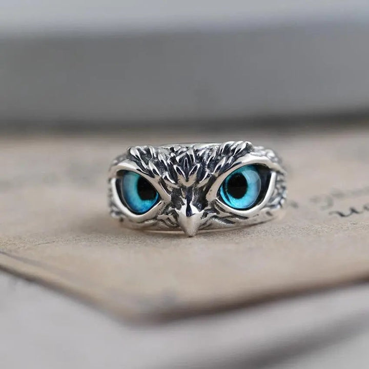 Anello da donna regolabile con gufo argentato e brillanti occhi blu zaffiro. Gioiello unico e alla moda.