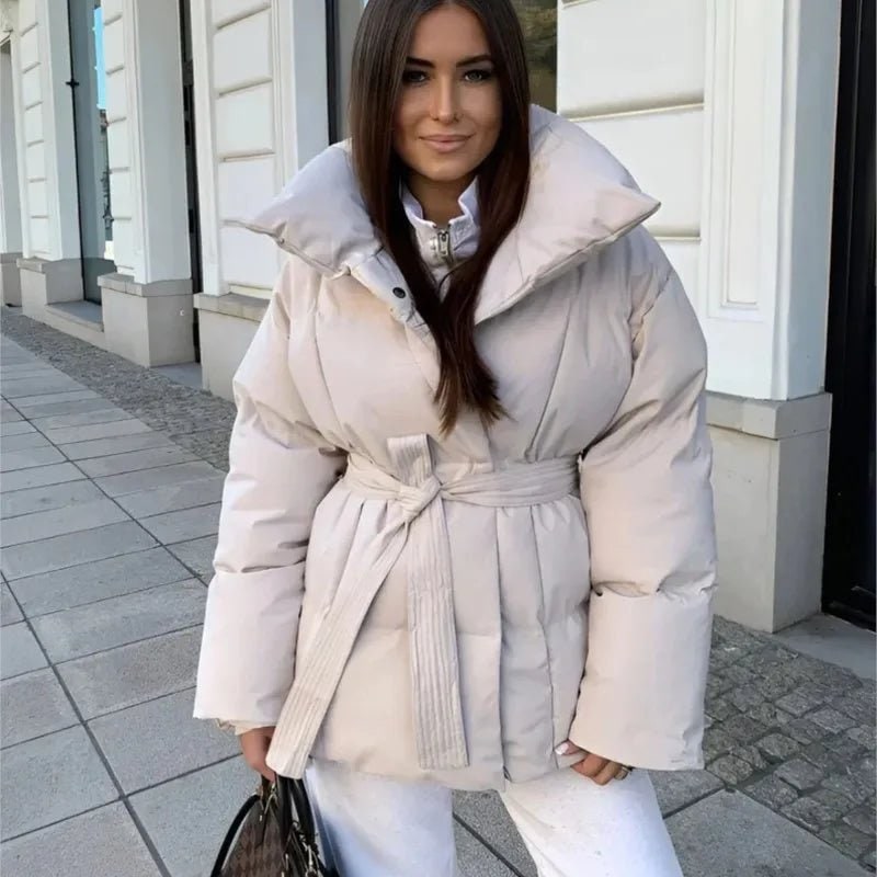 Elegante giacca puffer donna oversize con cinto e collo alto. Ideale per un inverno caldo e alla moda.