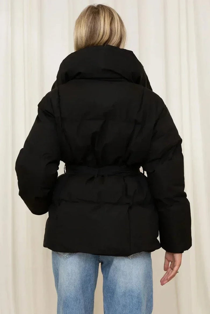 Giacca puffer donna frontale, oversize, con cinto e collo alto. Dettagli raffinati per un look invernale chic.