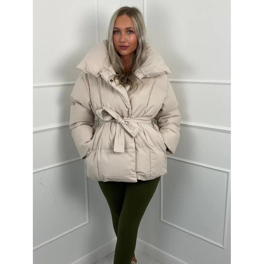 Giacca puffer donna raffinata con cinto. Collo alto e vestibilità oversize per un look chic e caldo in inverno.