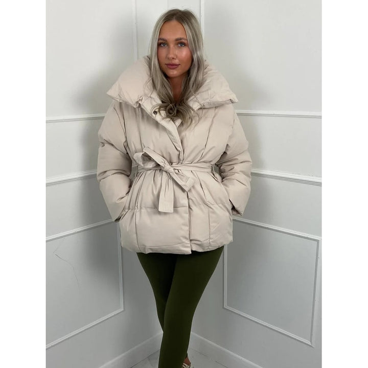 Giacca puffer donna raffinata con cinto. Collo alto e vestibilità oversize per un look chic e caldo in inverno.