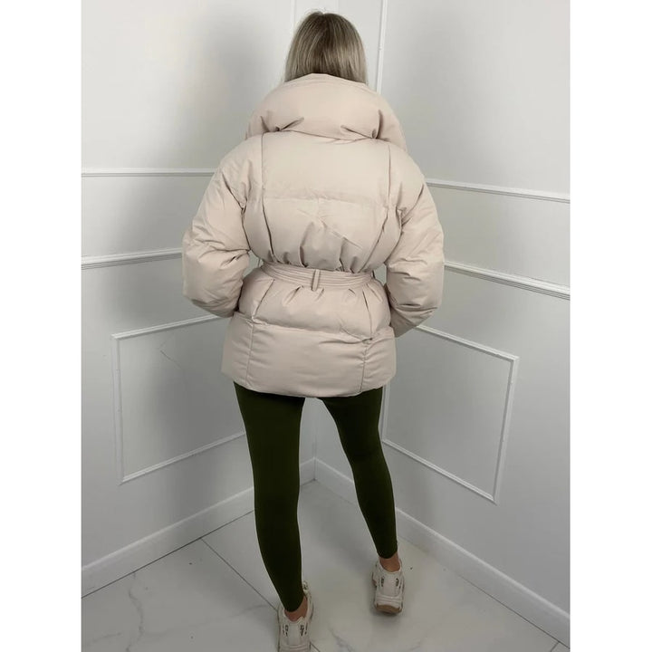 Giacca puffer donna con cinto regolabile e collo alto. Vestibilità oversize per un outfit invernale stiloso e caldo.