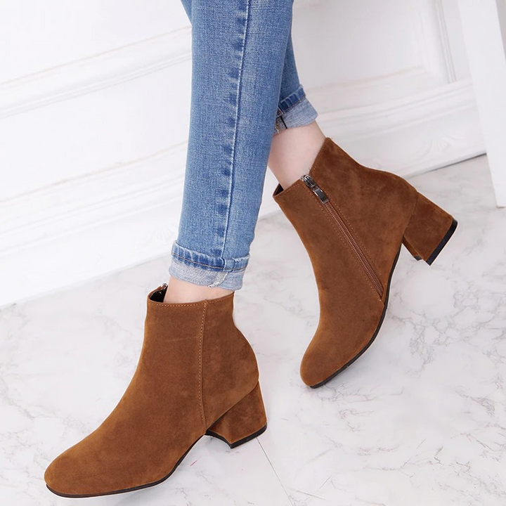 Eleganti stivaletti donna con tacco largo e cerniera. Scarpe moda per l'inverno, uniscono stile e comfort.