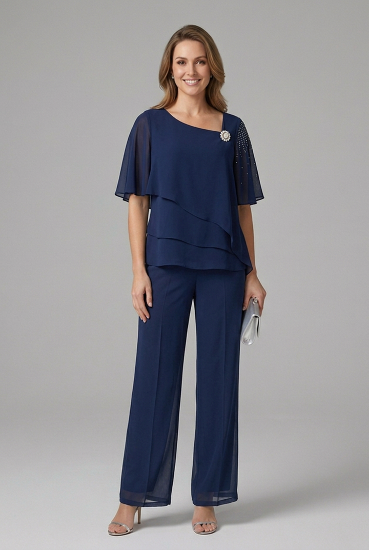 Completo donna glamour con pantaloni gamba larga e top stratificato, impreziosito da strass e spilla perle.